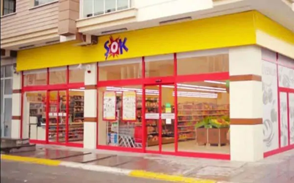 Sarı tabelalı ve kırmızı çerçeveli camları olan bir Şok Market köşe mağazası