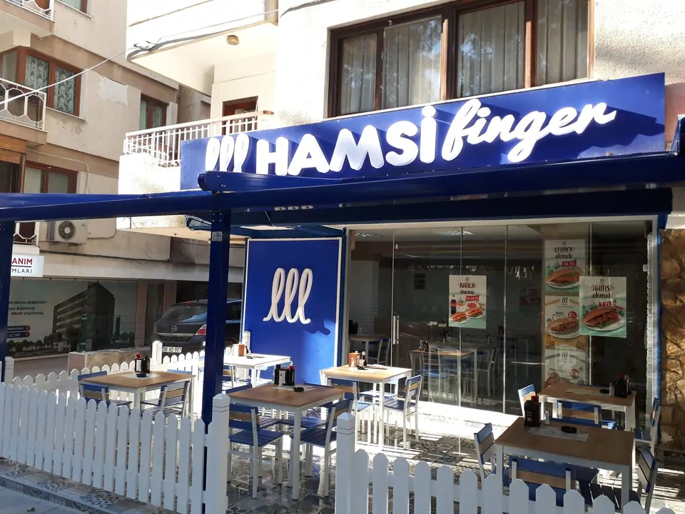 Hamsi Finger şubesinin mavi tabelalı cephesi ve önündeki açık hava masaları, Hamsi Finger bayilik ücreti ne kadar? 2026 franchise modelleri, şartları ve başvuru yolu Hamsi Finger şubesinin mavi tabelalı cephesi ve önündeki açık hava masaları
